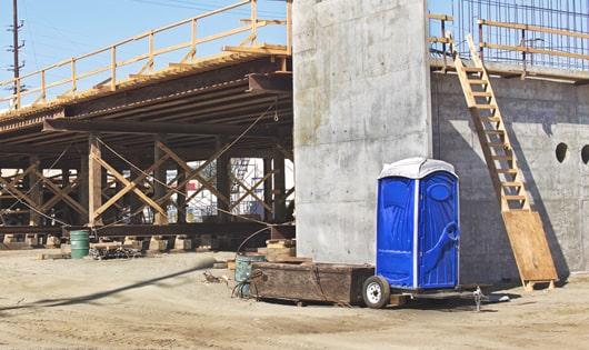 a row of modern portable toilets at a busy work site, designed for easy use and maintenance